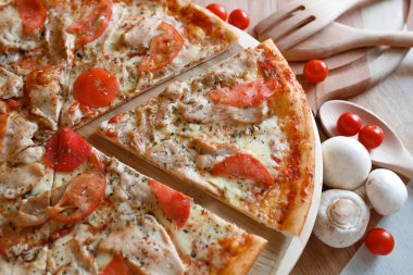 Etrafında pizza ve malzeme var.