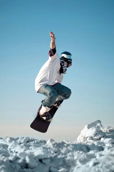 Snowboarder faisant saut contre le ciel bleu clair — Photo