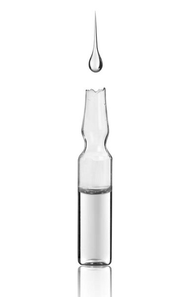 a drop of medicine falls into the ampoule on white background 