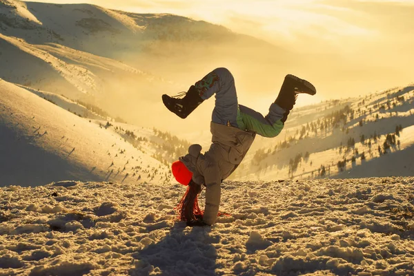 Menina em pose acrobática em pé em um topo da montanha ao pôr do sol — Fotografia de Stock