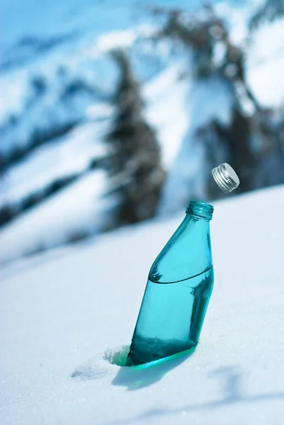 Szklana butelka wody mineralnej na tle alpejskich krajobrazów — Zdjęcie stockowe