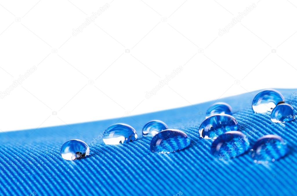 Waterproof fabric with waterdrops close up, on white background 