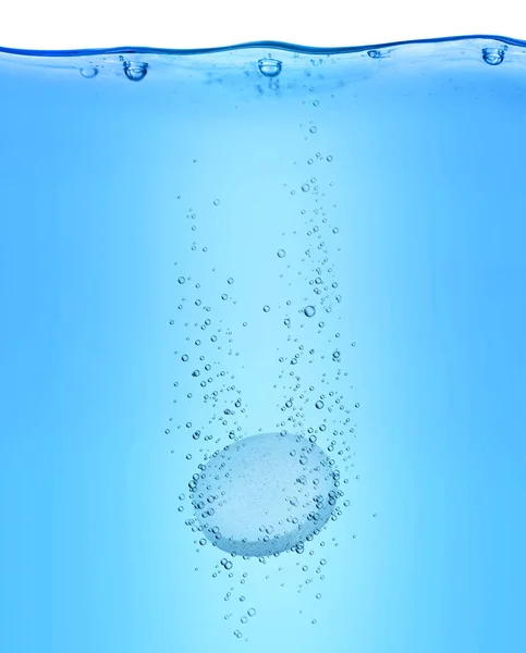 Pille löst sich in blauem Wasser auf — Stockfoto