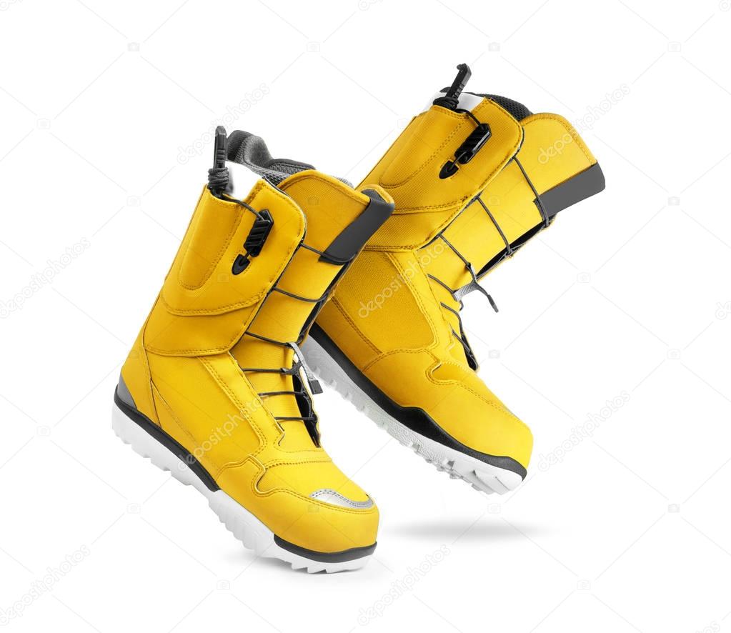 Technological yellow snowboard boots on white background