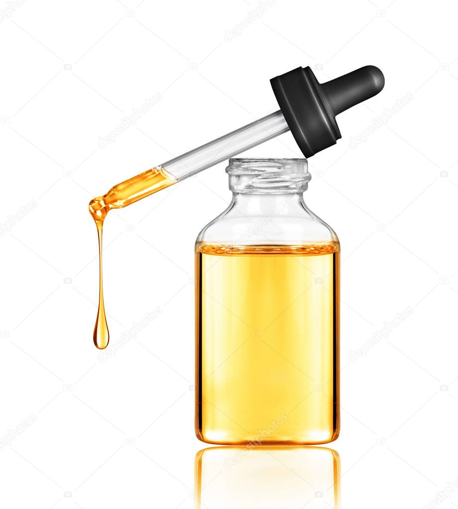 Oily drop falls from a cosmetic pipette, isolated on white background