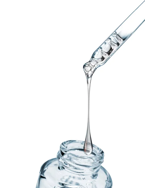 Druppel valt van een precisiepipet in een cosmetische fles close-up — Stockfoto