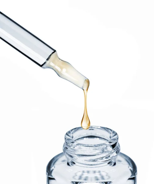 Droppe faller från en kosmetisk ampull i en flaska närbild — Stockfoto