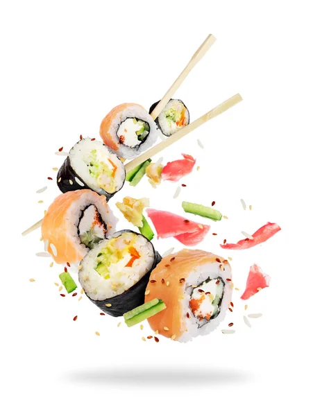 Diferentes rolos de sushi fresco com pauzinhos congelados no ar — Fotografia de Stock