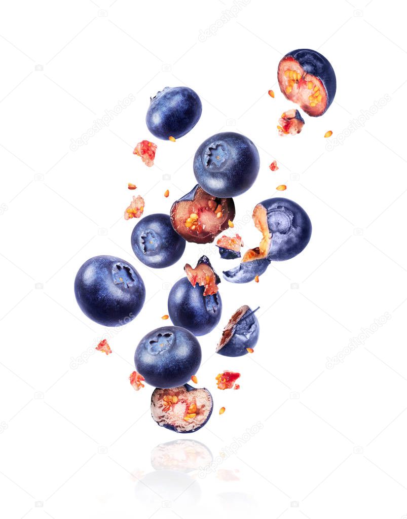Whole and sliced fresh blueberries in the air, isolated on a white background