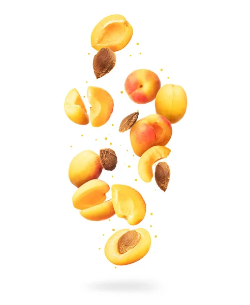 Frische ganze und in Scheiben geschnittene frische Aprikosen in der Luft auf weißem Hintergrund — Stockfoto