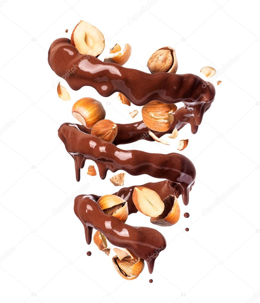 Chocolate splashes in spiral shape with crushed hazelnuts, isolated on a white background