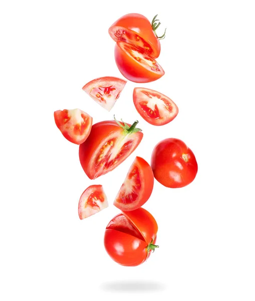 Ganze und in Scheiben geschnittene frische Tomaten fallen auf weißem Hintergrund herunter — Stockfoto