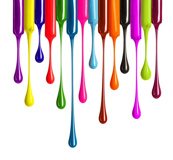 Colorful drops of nail polish drip from brushes close-up on white background — Stock Photo, Image