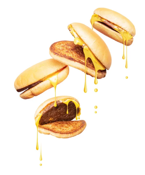 Cheeseburgers met gesmolten kaas vallen neer op een witte achtergrond — Stockfoto