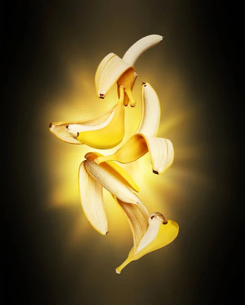 暗闇の中で光の点滅で空気中のバナナを開きます — ストック写真