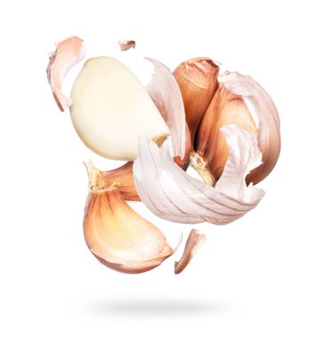 Garlic unfolds in the air close-up on a white background clipart