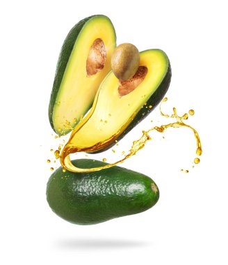 Tam ve dilimlenmiş avokado, beyaz arka planda izole edilmiş biraz meyve suyu.
