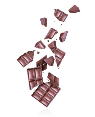 Gözenekli siyah çikolata, beyaz arka planda havada ezilmiş.