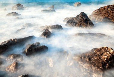 Taşlı bir okyanusun uzun pozlama fotoğrafı