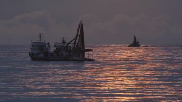 Um barco de pesca pesca no mar . — Vídeo de Stock