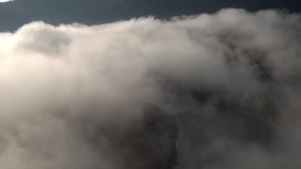 4K aerial view. Low flight above the clouds with mountains green trees. — Stock Video