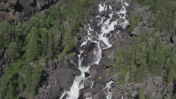 Aproximación aérea a una cascada rocosa. Vista del valle con un poderoso río cayendo. 4k — Vídeos de Stock