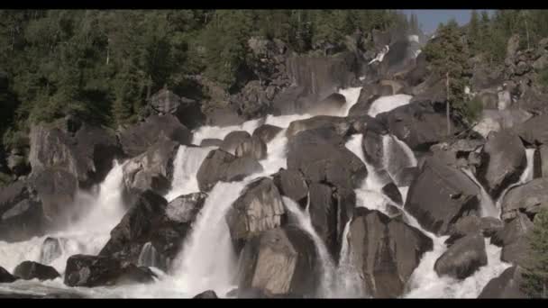 Kayalık bir şelaleye uçan bir yaklaşım. Güçlü bir nehri olan vadinin manzarası. — Stok video