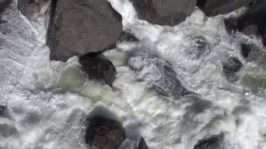 Kayalık bir şelaleye uçan bir yaklaşım. Güçlü bir nehri olan vadinin manzarası.