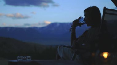  Kadın ve erkek balkonda şarap içip sohbet ediyorlar. Güzel dağ manzarası 4k