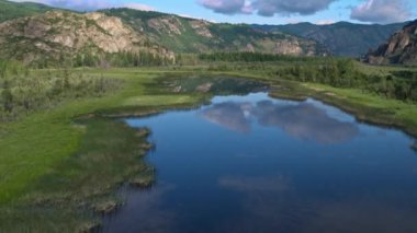 Flying over the river in the water reflected clouds background mountains 4k