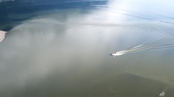 Barco a motor de alta velocidad, un barco corriendo a lo largo del lago a la orilla del pueblo 4k — Vídeo de stock