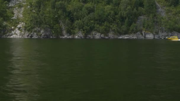 Prise de vue depuis un bateau à moteur flottant sur les vagues, vue d'un bateau jaune qui passe 