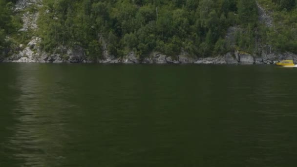 Shooting from a motor boat bobbing on the waves, a view of a passing yellow boat — 비디오