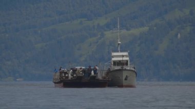Motor ship. Ferry crossing the lake. Cars and people are sailing on the ferry 4k