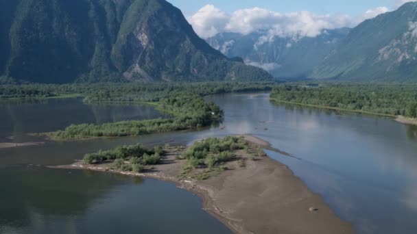 Volando sobre un río que desemboca en un lago sobre el telón de fondo de las montañas 4k — Vídeo de stock