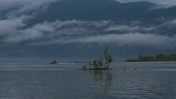 Motorboot schwimmt auf dem Fluss im Nebel vor dem Hintergrund der Berge — Stockvideo