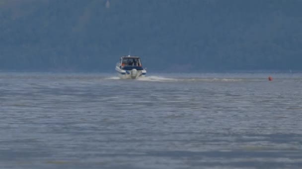 Snabb motorbåt, en motorbåt racing genom lugna vatten i sjön — Stockvideo