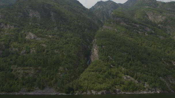 Sparatoria da una barca a motore che ondeggia sulle onde verso la riva della cascata — Video Stock