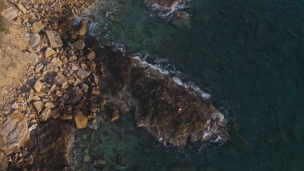 Fotografía aérea como una niña bailando en un cabo, acantilado, orilla del mar 4k — Vídeo de stock