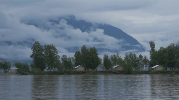 Tienda de campaña ciudad en el río Banco sobre el fondo de montañas, nubes y niebla — Vídeos de Stock