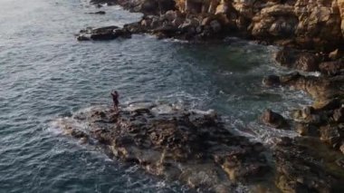 Cape, cliff, sea shore 4k 'de dans eden bir kız olarak hava fotoğrafçılığı.
