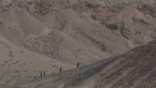 Los turistas suben a la montaña. Desierto, arena, fluctuación del aire del calor — Vídeos de Stock