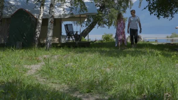 Een jongen en een meisje lopen langs een pad in het bos hand in hand, pratend — Stockvideo
