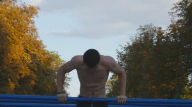 Gönderme yapan atletik erkek paralel Bar şehir parkında yer spor, ups. Yaz aylarında açık eğitim güçlü genç kas adam. Atlet parkında egzersiz. Egzersiz sağlıklı yaşam tarzı. Portre