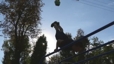 Güçlü kas adam amuda bir parkta. Kaslı erkek spor adamı yatay çubuklarında açık stunts yapıyor. Sporcu eğitim kas dışında bir hareketten gerçekleştirir. Egzersiz spor yaşam tarzı