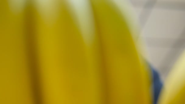 Manlig hand välja bananer på stormarknaden. Man tar ett gäng bananer från räknare i en livsmedelsbutik. Kille att välja färsk frukt på råvaror Institutionen för butiken. Köparen väljer mat. Närbild — Stockvideo