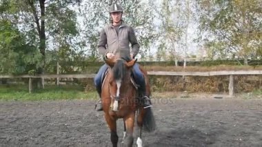 Açık genç adam binicilik. Erkek jokey at çiftliğinde modacı, karanlık bulutlu gün yürüyüş. Arka plan, güzel doğası. Aygır kapatın. Hayvan sevgisi
