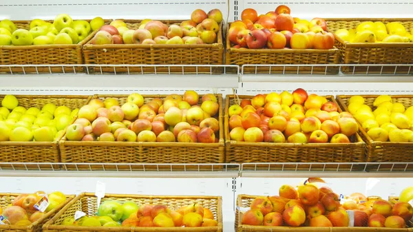 Moving past fresh fruits in a supermarket grocery. Shelves at the shop. Close up