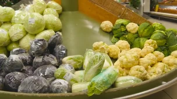 Pasando las verduras frescas en un supermercado. En los pasillos de la tienda. De cerca. — Vídeo de stock