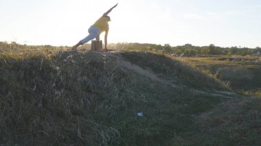 Beyaz adam pratik Yoga hamle ve doğada konumlandırır. Yoga poz açık ayakta sportif delikanlı. Dengeleme atlet. Güzel manzara arka plan olarak. Sağlıklı aktif yaşam tarzı